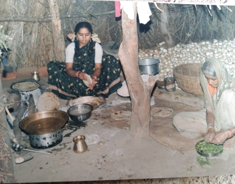 झोपडीतील चुलीवर स्वयंपाक करताना महिला